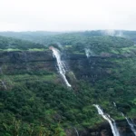 Dense forested hills with waterfalls, representing a biodiversity hotspot landscape in India