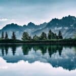 Understanding Environment and Ecosystem Variances: Mountain landscape with trees and lake, showcasing nature's interconnected beauty