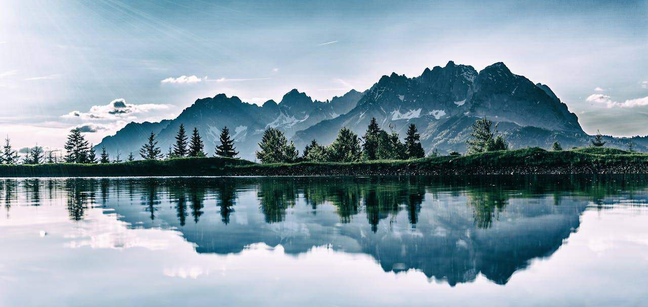 Understanding Environment and Ecosystem Variances: Mountain landscape with trees and lake, showcasing nature's interconnected beauty