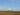 Wind turbines generating renewable energy in an open field under a clear sky.