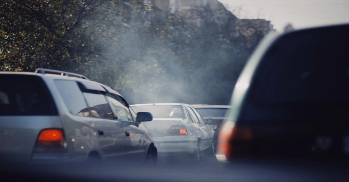 Vehicles emitting thick smoke from exhaust pipes, contributing to air pollution and harming air quality.