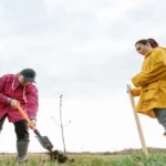 Volunteers planting young trees to promote afforestation and improve environmental sustainability.