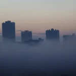 City skyline covered in dense smog, reflecting environmental pollution affecting air quality and climate